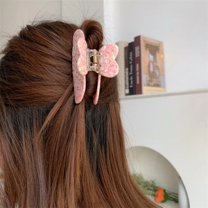 Pink butterfly hair claw with floral texture shown in a sweet lifestyle setting