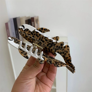 Détail d'une grande pince à cheveux en forme de requin avec un motif léopard et texture