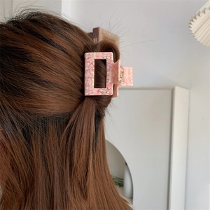 Pink peach blossom marble acetate hair claw clip styled on a woman's hair in a back view