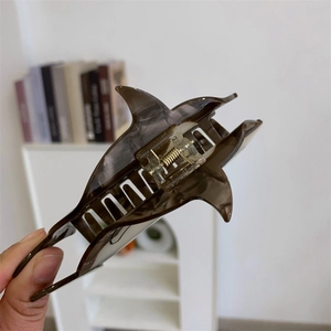 Détail de la pince à cheveux requin montrant le motif écaille et le ressort métallique