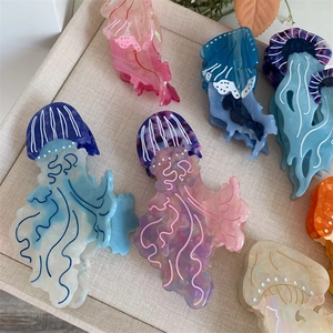 Mollette per capelli a forma di medusa in acetato marmorizzato su vassoio intrecciato