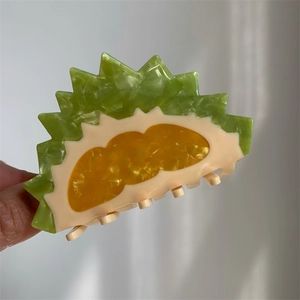 Detailed view of creative durian shaped acetate hair claw clip with forest green and yellow