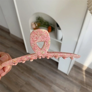 Detailed close-up of pink and cream marble texture acetate shark hair claw clip