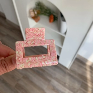 Detail showing the pink marble texture on a square acetate hair claw clip for women