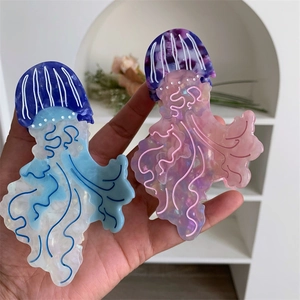 Dettaglio delle mollette per capelli a forma di medusa con trama marmorea e perlata