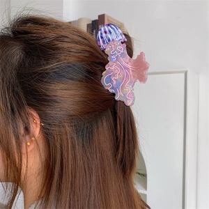 Dettaglio della molletta per capelli a medusa viola indossata su un'acconciatura