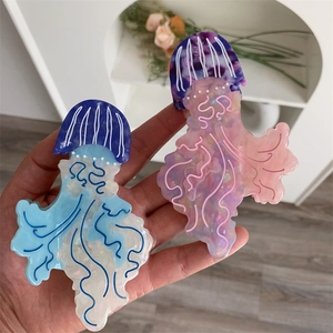 Dettaglio di due mollette per capelli a medusa in acetato traslucido blu lago e rosa