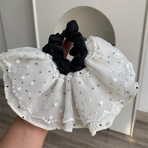 Detail showing oversized white mesh scrunchie with black polka dots and lace embroidery