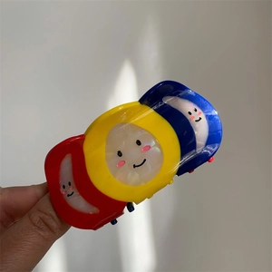 Close-up of creative three-color acetate hair claw clip with cute smiley faces detail