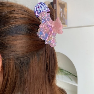 Dettaglio del fermaglio a medusa in acetato con sfumatura viola e rosa sui capelli lunghi