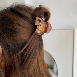 Detail view of coffee marble acetate hair claw clip worn on hair with glossy finish