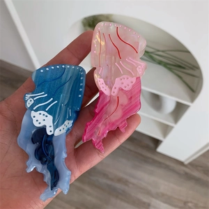 Dettaglio dei fermagli per capelli a medusa con sfumatura glitter rosa e blu