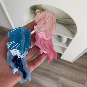 Dettaglio ravvicinato delle mollette per capelli a forma di medusa in blu navy e rosa lucido