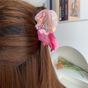 Pinza per capelli a forma di medusa in acetato rosa perlato su capelli castani
