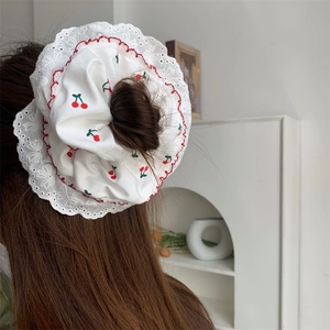 Elastico per capelli in pizzo con ciliegie indossato su capelli lunghi e setoso