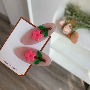 Vista dettagliata di due fermagli per capelli in resina con fiori 3D e petali rosa