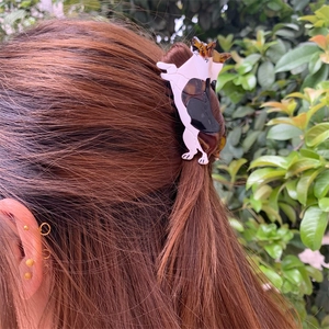 Detail of a Corgi style acetate hair claw clip showing dog shape and tricolor texture