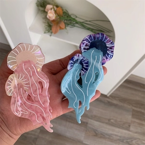 Dettaglio delle mollette per capelli a medusa in acetato rosa pastello e blu viola