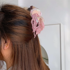 Pinza per capelli a medusa rosa in acetato su capelli castani con riflessi lucidi