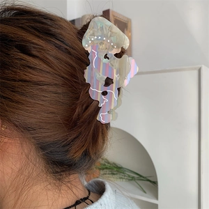 Dettaglio della molletta per capelli a forma di medusa in acetato colorato indossata
