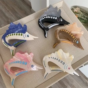 Detailed close-up of five acetate marlin fish hair claws in various marble colors