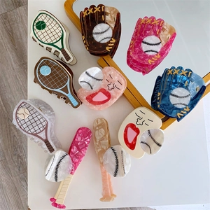 Detail shot of sport-themed acetate hair claws including tennis rackets and baseball designs