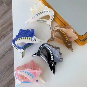 Close-up of five colorful acetate swordfish hair claws with marble texture in ocean style