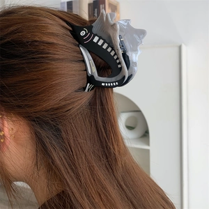 Detailed back view of a medium fish-shaped acetate hair claw clip in a half-up hairstyle