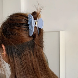 Detailaufnahme der hellblauen Haarspange mit Engelsflügeln und weißen Strasssteinen