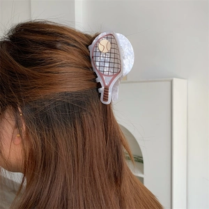 Detail view of tennis racket hair claw clip in acetate material on hair