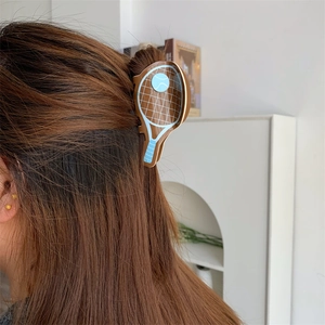 Detail view of tennis racket hair claw clip in acetate worn on long brown hair