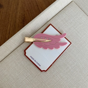 Detail der rosa Flügel Haarspange mit weißen Strasssteinen und goldener Metallklemme