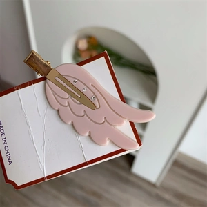 Nahaufnahme der rosa Flügel-Haarklammer mit Kristallen und goldener Metallbasis