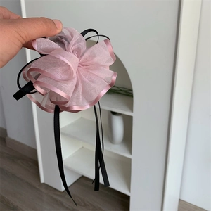 Dettaglio molletta per capelli con fiore in organza rosa, nastri neri e rete leggera