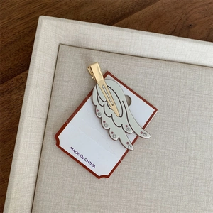 Detailansicht der Haarspange in Flügelform mit rosa Strasssteinen auf Gold-Schnabelclip