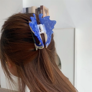 Detailed close-up of blue acetic acid butterfly hair claw clip styled on brunette hair