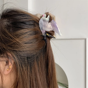 Eleganter Schwalben-Haarclip aus Acetat mit Farbverlauf auf braunem Haar getragen