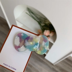 Detail of candy-colored acetate hair clip with tie-dye marble texture on display card