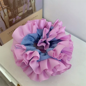 Detail of pink and blue contrast pleated scrunchie with striped fabric texture