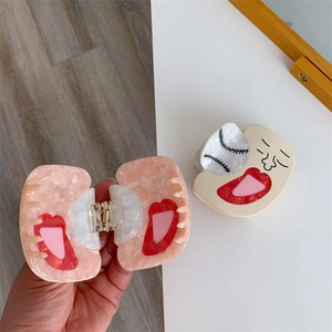 Detail showing creative acetate hair claw clip with baseball pattern and marble texture