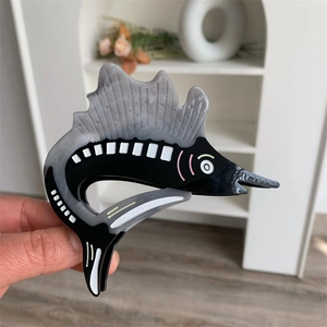 Detail of a swordfish acetate hair claw clip with black and grey striped patterns