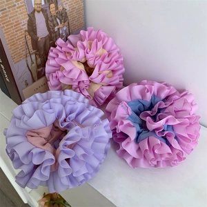 Detailed close-up of textured layered scrunchies in colorful pastel pleated fabric
