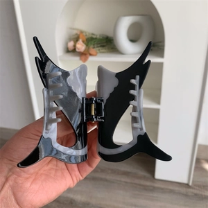 Detailed close-up of marble pattern acetate shark hair claw clip in grey and black
