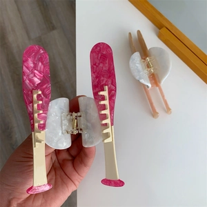 Detail of creative tennis racket hair claw clip featuring marble texture acetate material