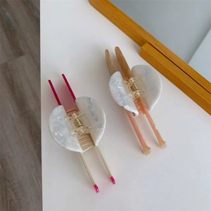 Close-up of marble pattern acetate hair claw clips with pink handles for long hair styling