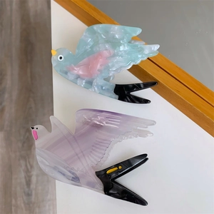Makro-Detail von Haarklammern in Vogelform aus Acetat mit Marmortextur und edlem Finish