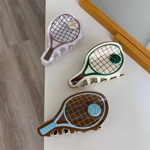 Three tennis racket hair claws in pink, green, and blue displayed on a white surface