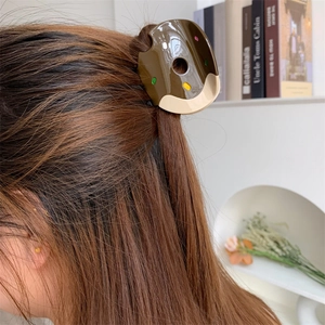 Sweet donut-shaped hair claw clip in dark brown and cream on brown hair