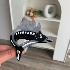 Detail view of a swordfish acetate hair claw clip featuring marble grey and black texture
