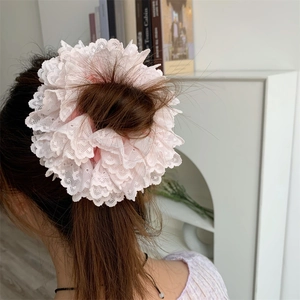 Close-up of a pink tiered lace scrunchie styled on a bun for a sweet aesthetic look